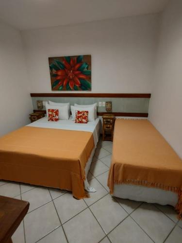 two beds in a room with two beds sidx sidx sidx at Pousada Caiçara in Abraão
