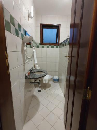 a bathroom with a sink and a toilet at Pousada Caiçara in Abraão