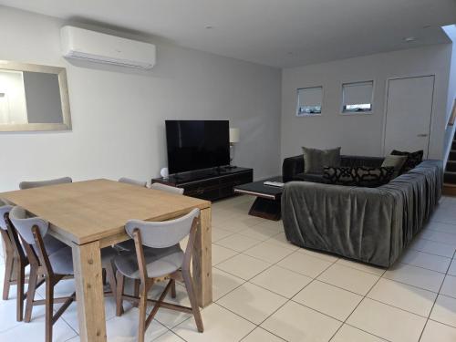 a living room with a table and a couch at Quarterdecks Retreat in Hervey Bay