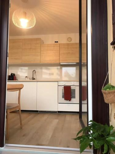 - une cuisine avec des placards blancs, un évier et une table dans l'établissement Le Studio Lumière - Balcony - 5min Part-Dieu, à Lyon