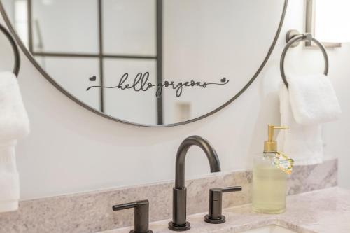 a bathroom with a sink and a mirror at Couples Retreat with Hot Tub, Beach Cruisers, Spa Bath in Kill Devil Hills