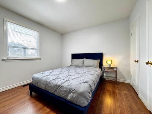 ein Schlafzimmer mit einem Bett in einem Zimmer mit einem Fenster in der Unterkunft 3 Bedroom Home In Ideal Location Near Yonge St in Markham