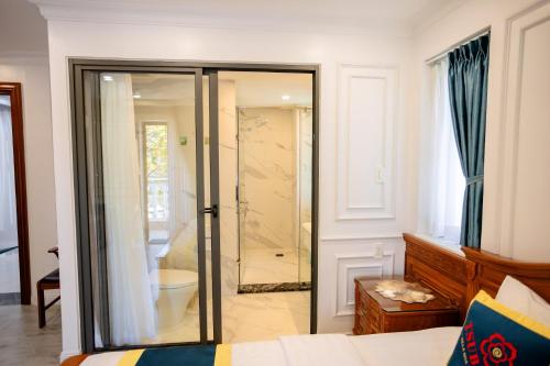 a bathroom with a walk in shower and a toilet at TSUBAKI VILLA nha trang in Nha Trang