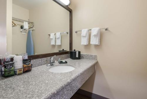 a bathroom with a sink and a mirror and towels at SureStay Hotel by Best Western Fernley in Fernley