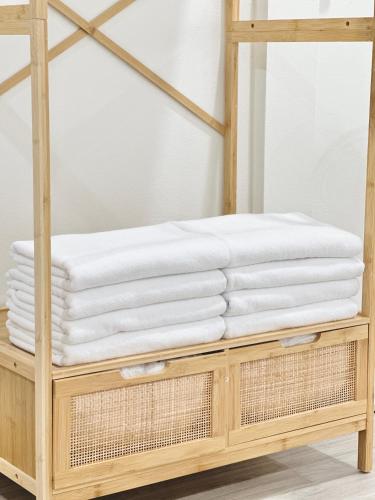 a stack of towels on a wooden shelf at Midori Haus-7mins to LeeGarden in Hat Yai