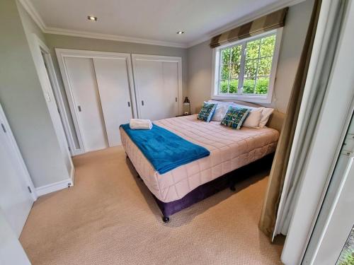 ein Schlafzimmer mit einem Bett und einem Fenster in der Unterkunft Blue Penguin - Russell Cottages Collection 2-4 Bedroom in Russell