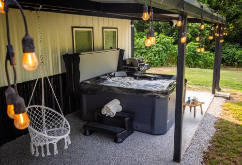 an outdoor hot tub with a table and a chair at Brazos River Escape, Hot Tub, Indoor Pickleball, Firepit, Fishing, Kayaking, Nature Trail in Waco