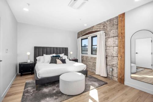 a white bedroom with a bed and a mirror at Group-Perfect - 3 Private Suites Downtown in Grand Rapids