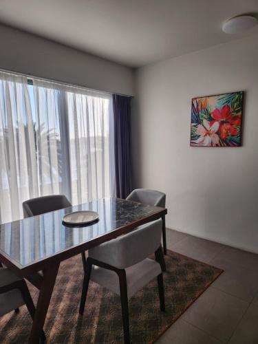 a dining room with a table and chairs and a window at Ramada Suites By Wyndham Seafront Coral Coast in Korotogo