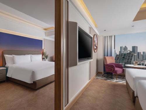 a hotel room with a bed and a flat screen tv at Pipa Hotel Bangkok Sukhumvit 11 in Bangkok