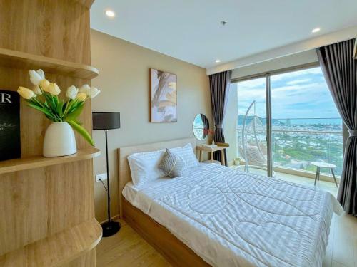 a bedroom with a bed with a vase of flowers at The Song Boutique Apartment in Vung Tau