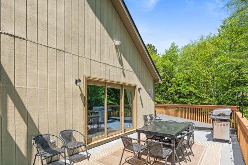 a patio with a table and chairs on a deck at Spacious Game Room Seclusion Hot Tub and more in Long Pond