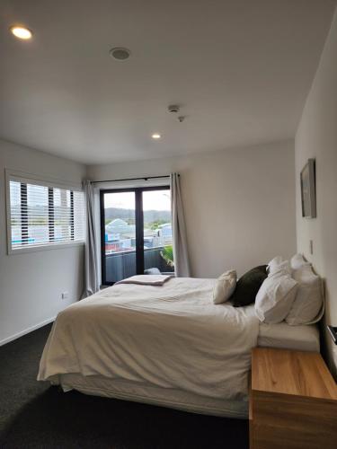 a bedroom with a large bed with a window at Rooftop Apartment in Raglan