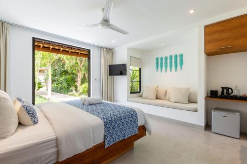 a bedroom with a bed and a window at Nature's Immersion Room at Anwa Bali Boutique Resort in Canggu