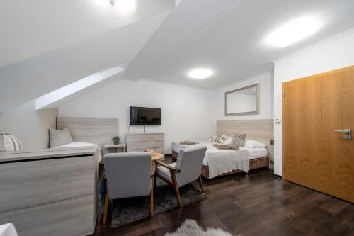 a bedroom with a bed and a table and chairs at Anenský Apartmán C303 s wellness , O2 TV a stabilní rychlou WIFI, s možností dokoupení bufetových snídaní a s možností dokoupení masáží in Harrachov