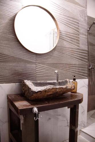 Un baño con un lavabo de piedra y un espejo. en Magic dreams san telmo, en Buenos Aires