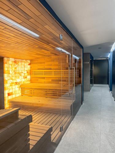 a sauna with wood paneling and a glass wall at Anenský Apartmán C303 s wellness , O2 TV a stabilní rychlou WIFI, s možností dokoupení bufetových snídaní a s možností dokoupení masáží in Harrachov