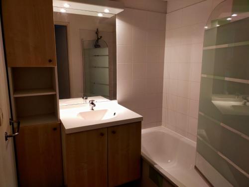 une salle de bain avec un lavabo et une baignoire dans l'établissement Appartement T4 avec Wi-Fi et parking dans résidence avec activités - FR-1-239-1125, à Ondres