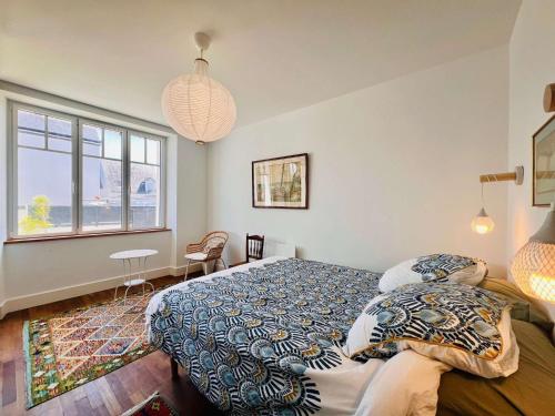 une chambre avec un lit et une grande fenêtre dans l'établissement Saint-Pierre-Quiberon - Villa spacieuse 9 pièces, 14 pers., grand jardin - FR-1-478-319, à Saint-Pierre-Quiberon