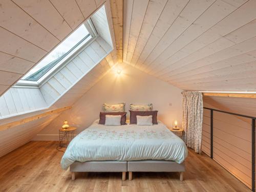 a bedroom with a large bed in a attic at Maison rénovée au bord de l'Ognon avec grand jardin et plage privée - FR-1-583-395 in Cenans