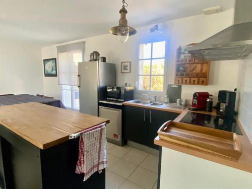 une cuisine avec un réfrigérateur et un plan de travail dans l'établissement Maison rénovée proche du bourg avec terrasse et jardin - FR-1-813-26, à Groix