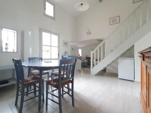 une salle à manger avec une table et des chaises et un escalier dans l'établissement Maison 4 chambres près plage, forêt, wifi, 8 pers - FR-1-476-241, à La Faute-sur-Mer