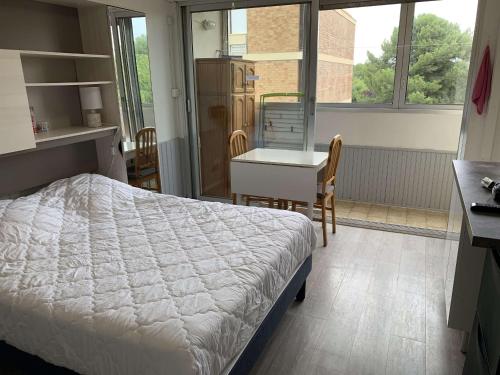 une chambre avec un lit, une table et un bureau dans l'établissement Studio rénové à Balaruc-les-Bains, proche Thermes - FR-1-553-304, à Balaruc-les-Bains