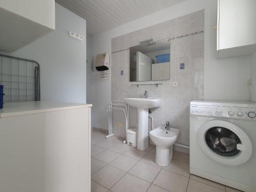 une salle de bain avec une machine à laver et un lavabo dans l'établissement Maison 4 chambres près plage, forêt, wifi, 8 pers - FR-1-476-241, à La Faute-sur-Mer