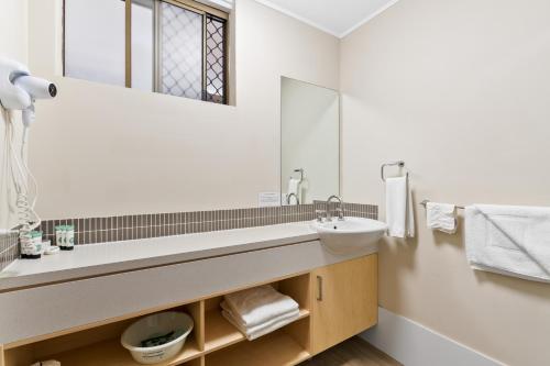a bathroom with a sink and a mirror at Morayfield Tavern in Morayfield