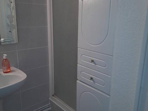 La salle de bains est pourvue d'un lavabo et d'une commode blanche. dans l'établissement Appartement 2P avec Clim, Terrasse et Parking, Le Barcarès - FR-1-782-76, au Barcarès