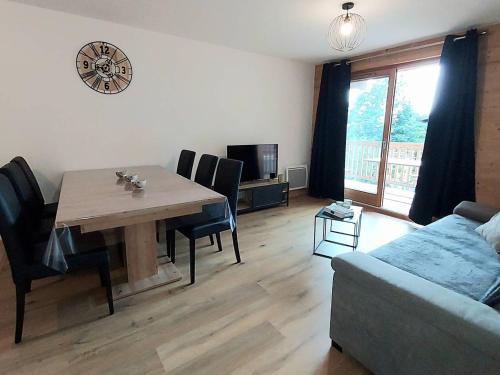 un salon avec une table et un canapé dans l'établissement Appartement cosy 6 pers, accès pistes, parking inclus - FR-1-356-536, à Valmorel