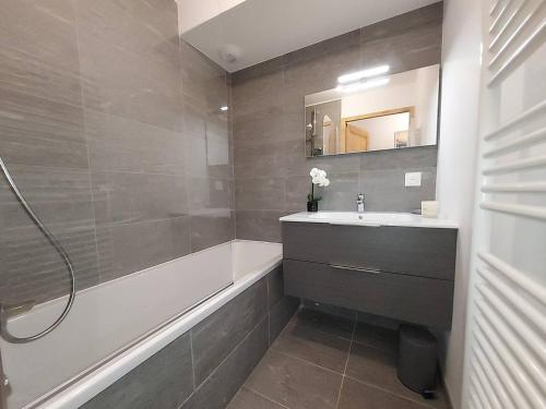 une salle de bain avec un lavabo, une baignoire et un miroir dans l'établissement Appartement cosy 6 pers, accès pistes, parking inclus - FR-1-356-536, à Valmorel