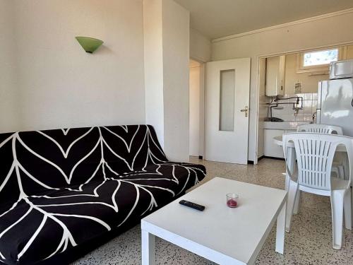 - un salon avec un canapé noir et blanc et une table dans l'établissement Appartement 2 pièces à 100m de la mer, Argelès-sur-Mer - FR-1-225-833, à Argelès-sur-Mer