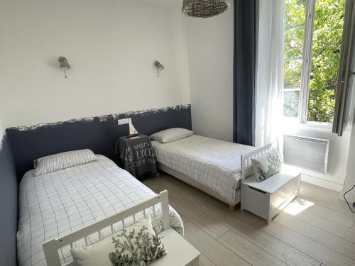 une petite chambre avec deux lits et une fenêtre dans l'établissement Maison charmante proche plage et commerces avec WIFI - FR-1-652-60, à Saint-Jean-de-Monts