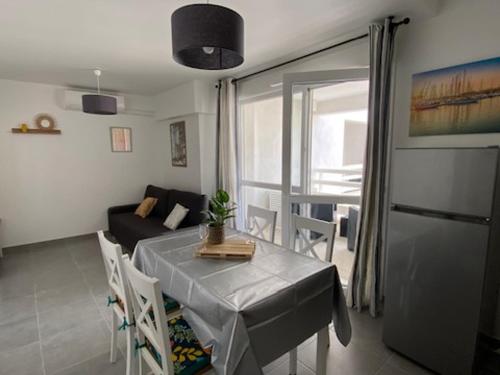 salon ze stołem i kanapą w obiekcie Superbe T2 Climatisé avec Terrasse - 4 Pers, Ascenseur, Parking Privé, à 400m de la Plage - FR-1-727-15 w mieście Port Leucate