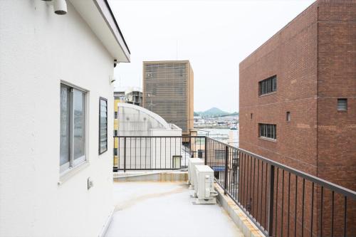a balcony of a building with snow on the ground at COCOSTAY尾道本通り - 千光寺も花火も雨の日も全部にやさしい尾道の宿 - In the middle of the shopping street in Onomichi