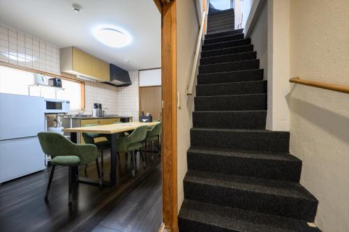 a staircase in a kitchen with a table and chairs at COCOSTAY尾道本通り - 千光寺も花火も雨の日も全部にやさしい尾道の宿 - In the middle of the shopping street in Onomichi