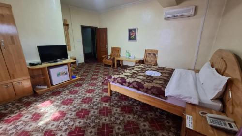 a hotel room with a bed and a tv and a room at Selbe Oyu in Ulaanbaatar