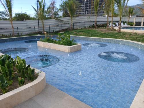 a swimming pool in a resort with palm trees at Un Espacio para soñar in Santa Marta