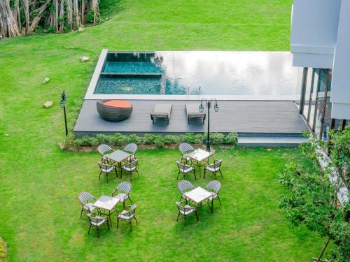 a group of tables and chairs in a yard with a pool at S48 River Ping in Chiang Mai