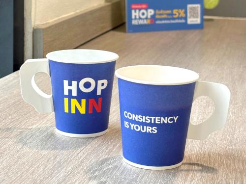 two coffee mugs are sitting on a table at HOP INN Saraburi in Sara Buri
