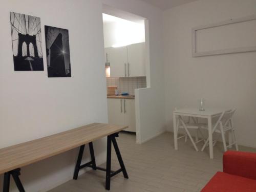 a living room with a table and a kitchen at Il Guasco Rooms in Ancona
