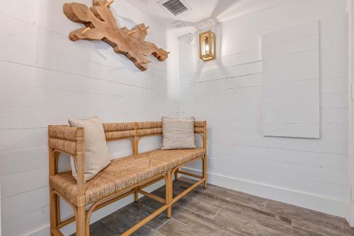 Un banco de ratán en una habitación con paredes blancas. en Newly Renovated San Luis Resort luxury condo, en Galveston