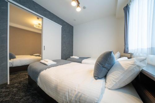a bedroom with two beds and a large mirror at MP STYLE SAPPORO-35 in Minami-jūichijō