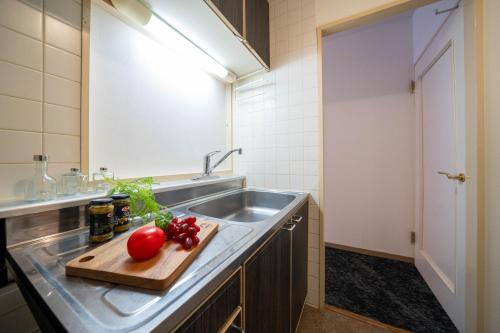 a kitchen with a sink and a cutting board with tomatoes at MP STYLE SAPPORO-35 in Minami-jūichijō