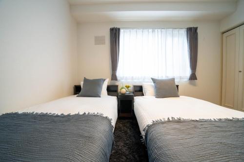 two beds in a room with a window at MP STYLE SAPPORO-35 in Minami-jūichijō