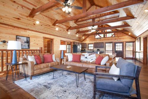 a living room with couches and tables in a cabin at Grace HideawayHUGESleeps20 Pool Hot Tub Games in Sevierville