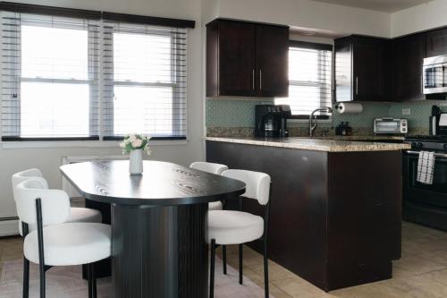 a kitchen with a table and some white chairs at 2BR Near OHare and Transit Newly Furnished Modern in Chicago