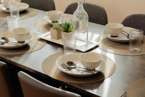 a table with plates and spoons and glasses on it at Nicostay Katsuura Beach in Fukuoka