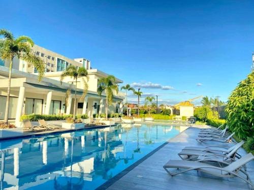 达沃市2BR Condo with Free Pool Access and Wifi的度假村的游泳池配有躺椅和棕榈树